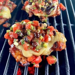 Grilling Monterey Chicken with cheese and salsa.