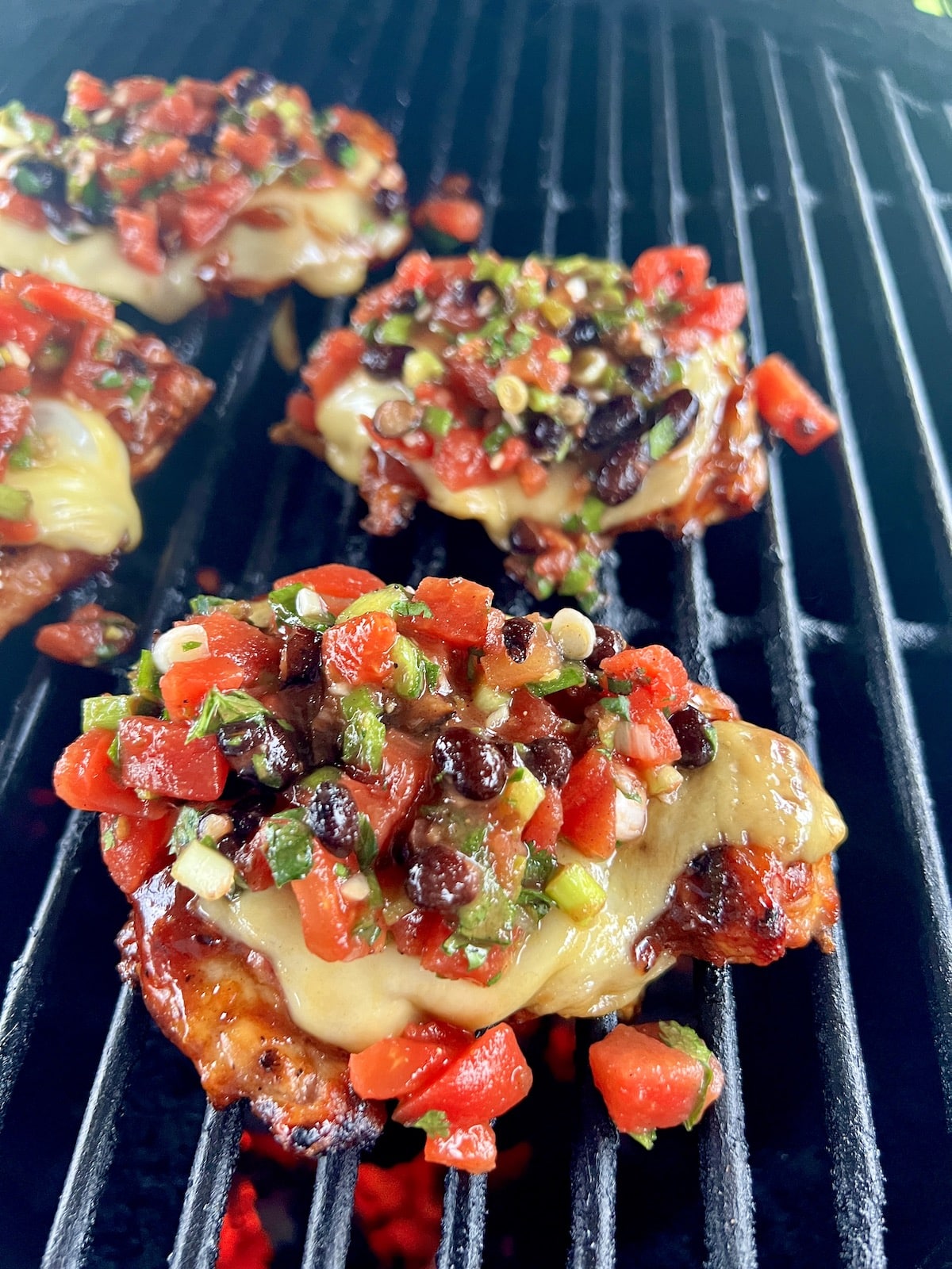 Grilling chicken with cheese and salsa.