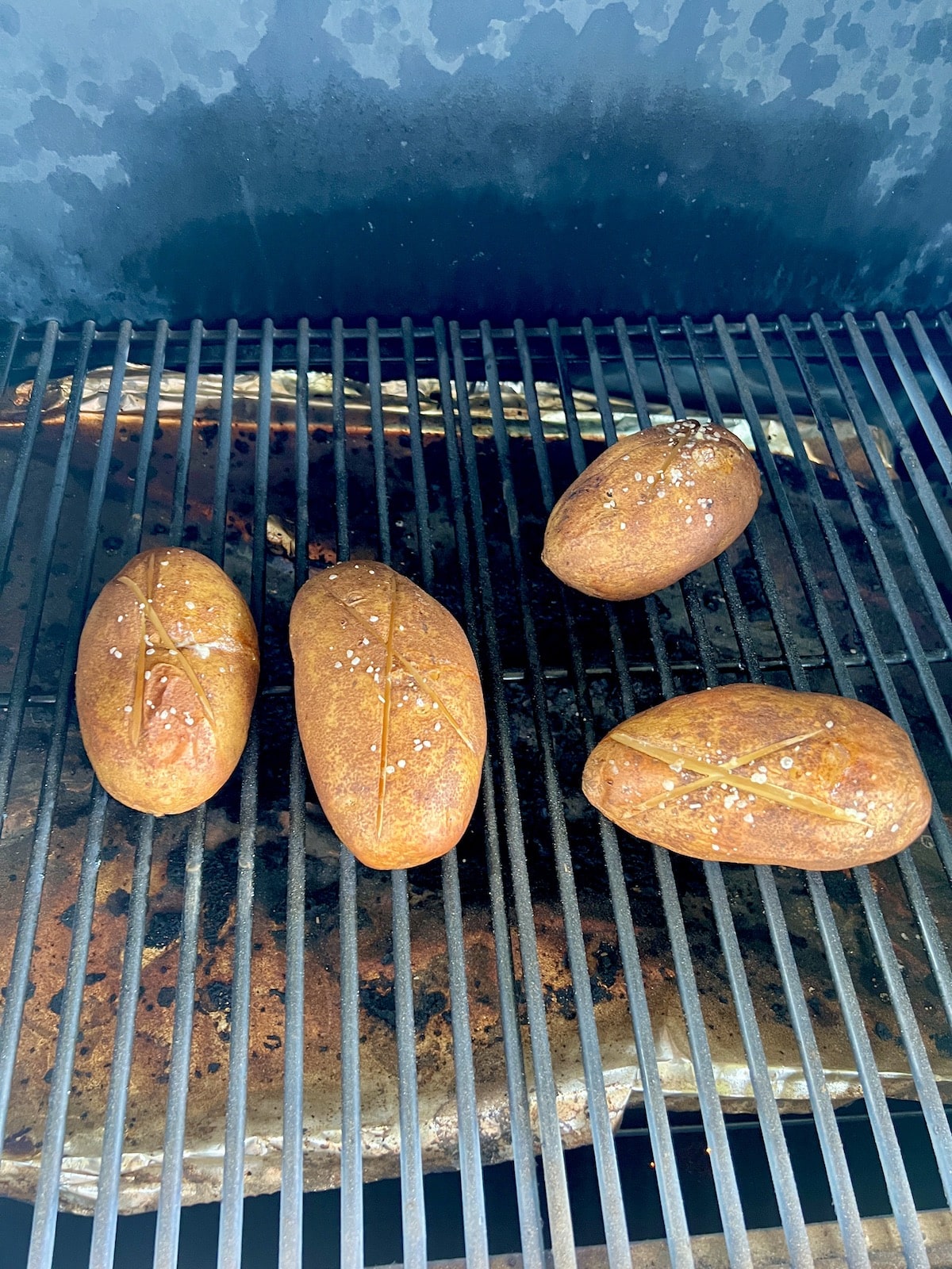 Cooking 4 baked potatoes on a pellet grill.
