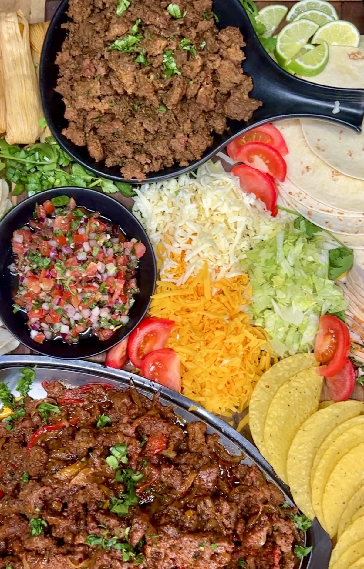 Mexican dinner board with ground beef, toppings, fajitas.