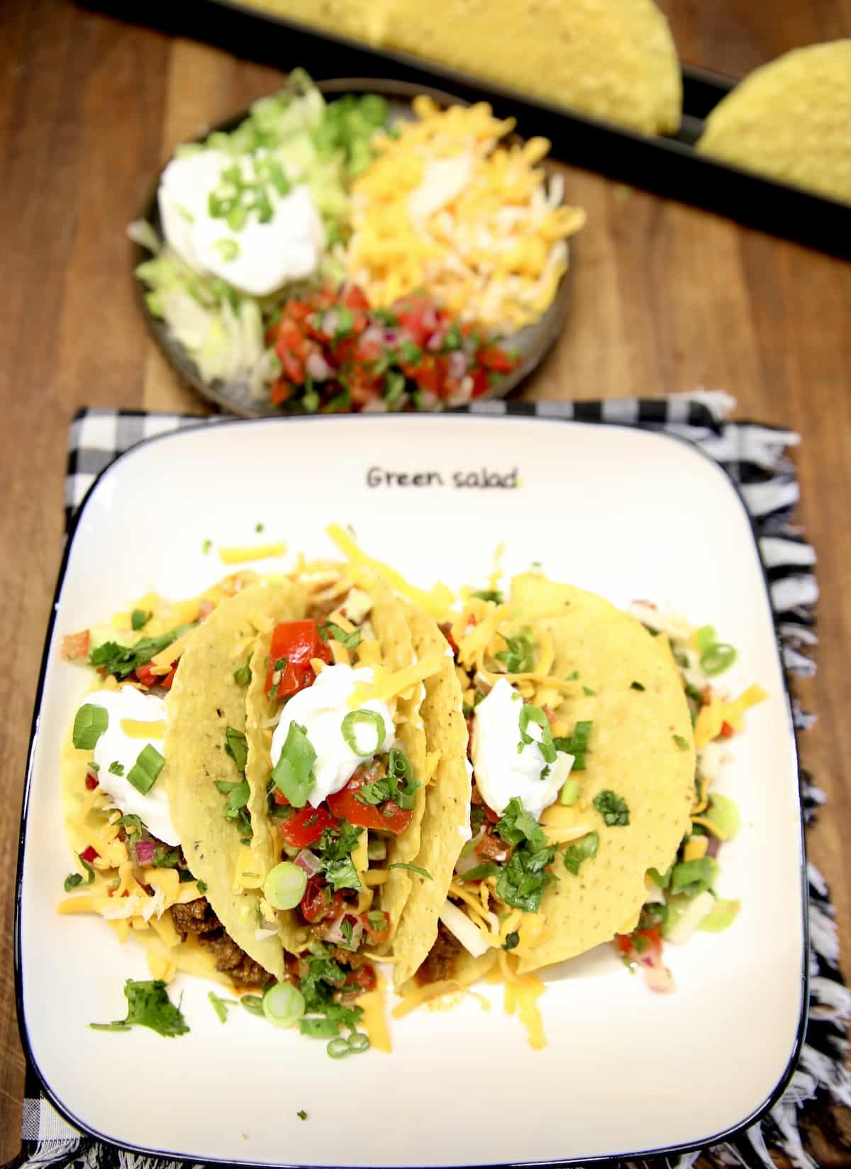 Ground beef tacos with sour cream, salsa.