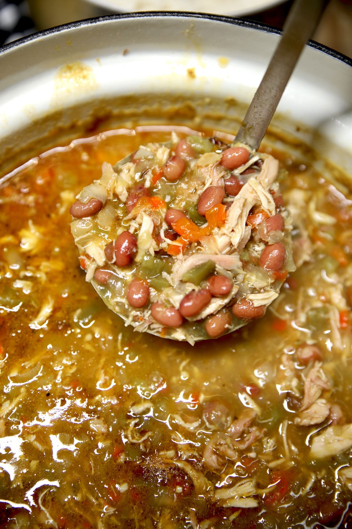 Ladle of red beans and rice with chicken soup.