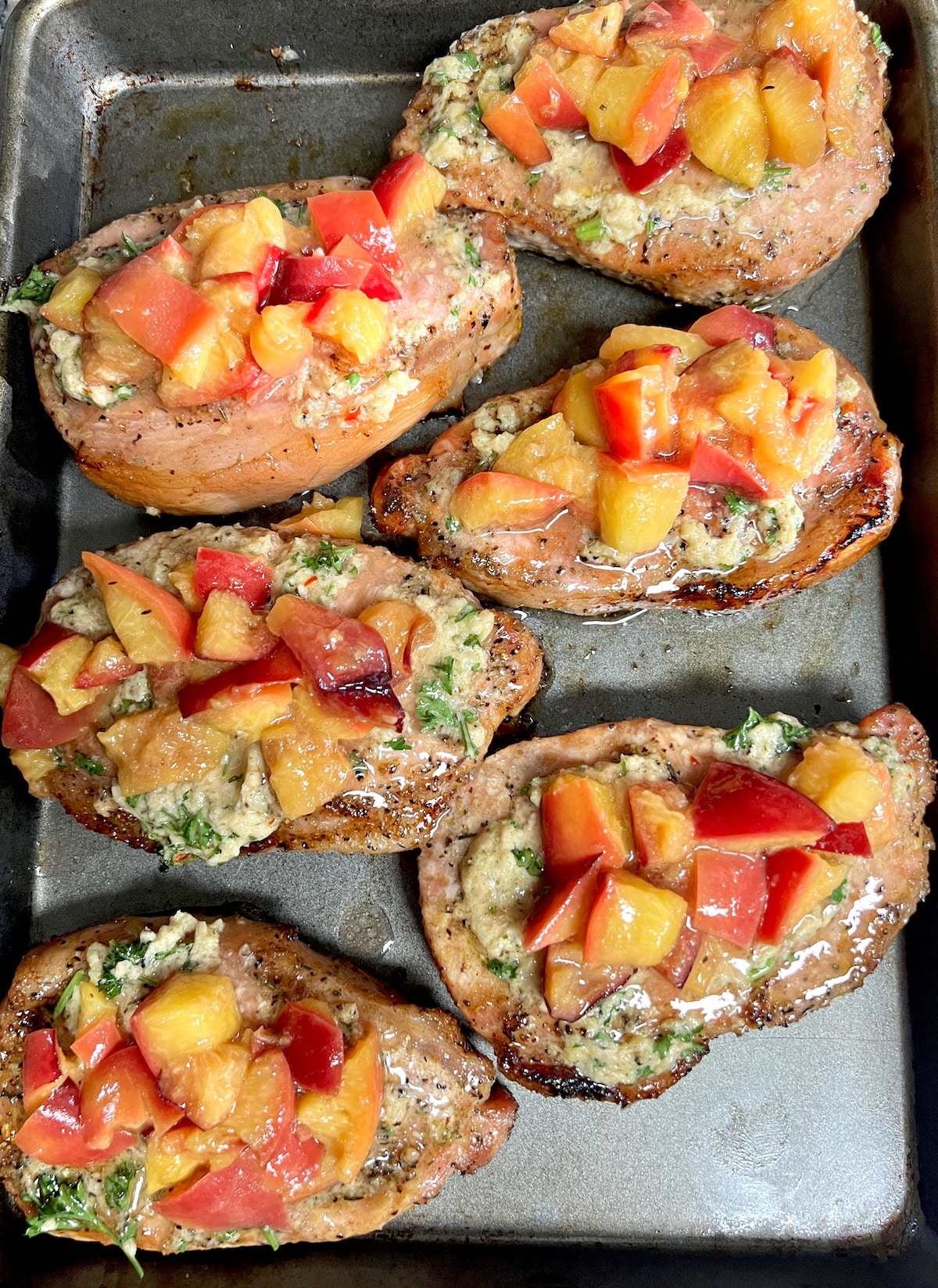 Grilled pork chops with cowboy butter and grilled peaches.