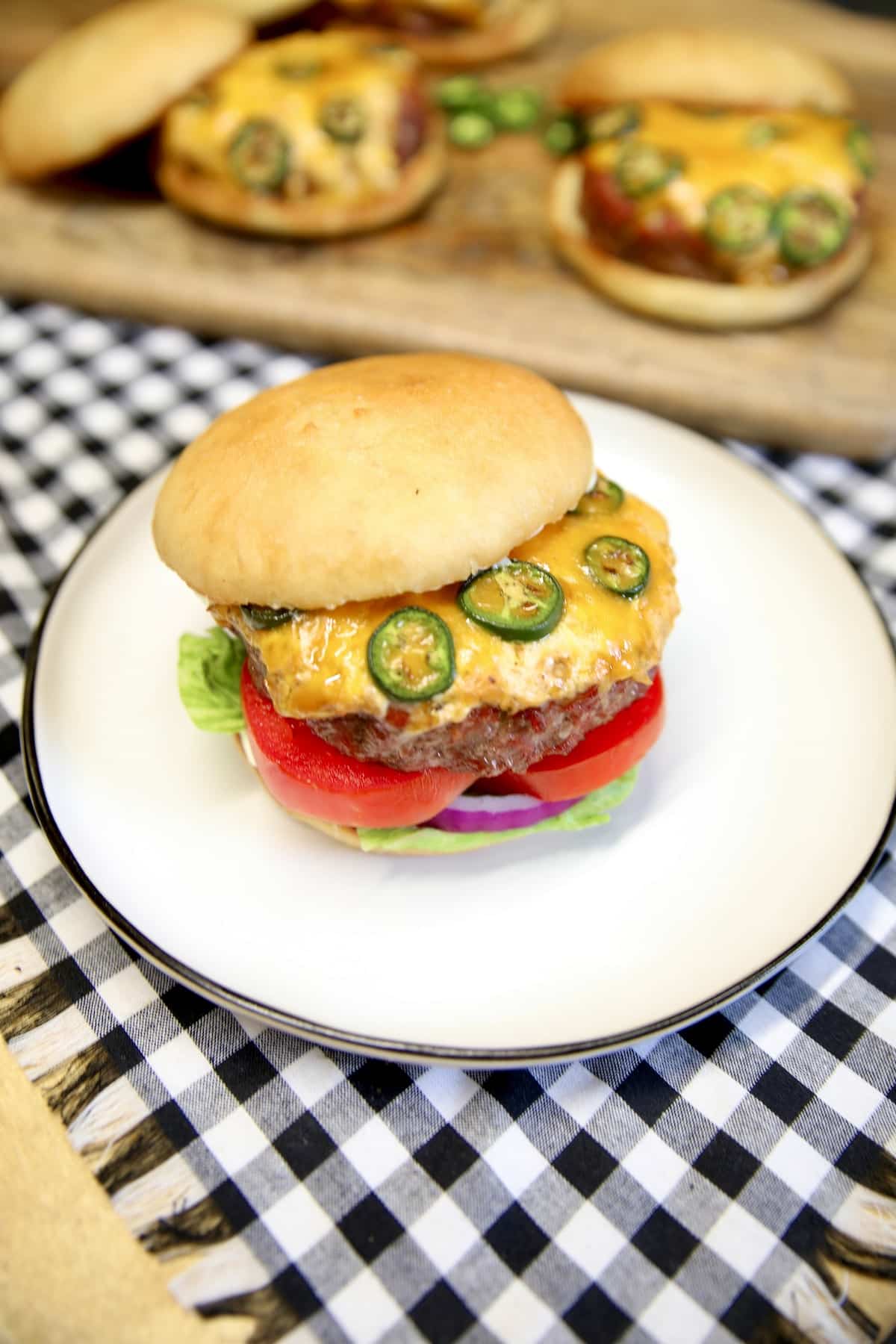 Burger with cheese and jalapeno filling on a plate.