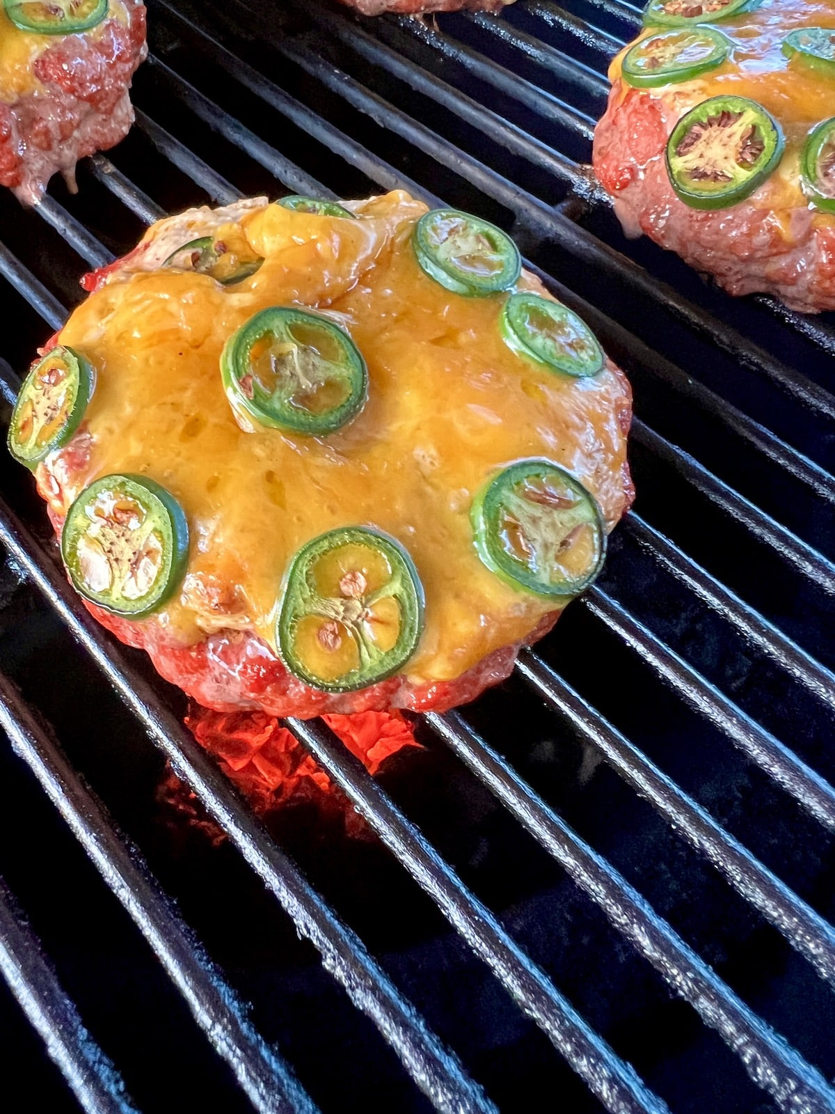 Grilling stuffed burgers with jalapenos.