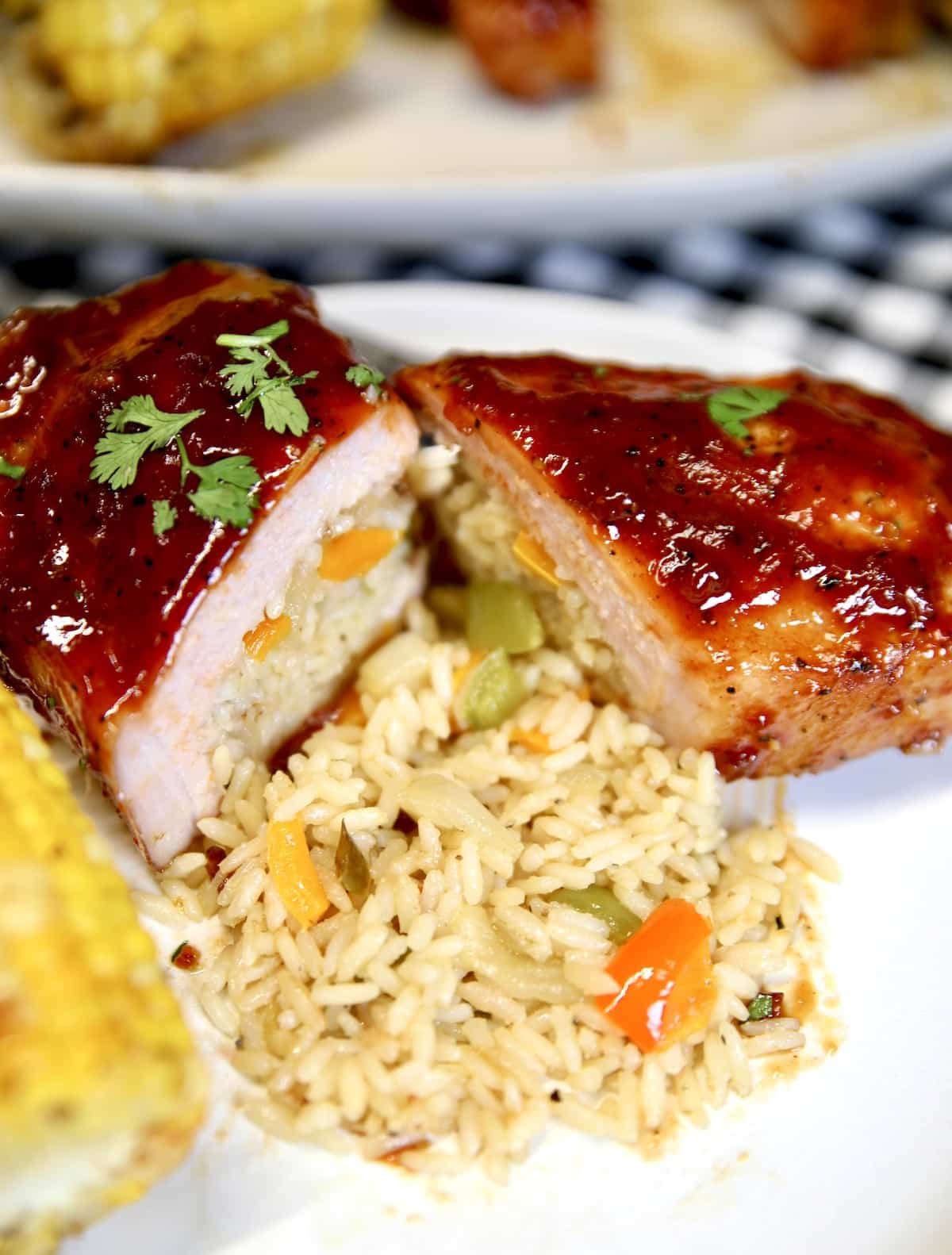 Pork chop with rice pilaf and corn on a plate.