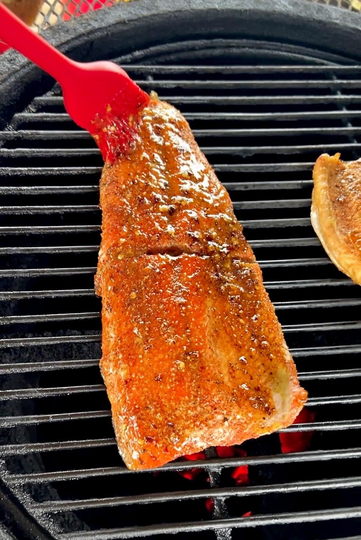 Brushing hot honey onto grilled salmon.