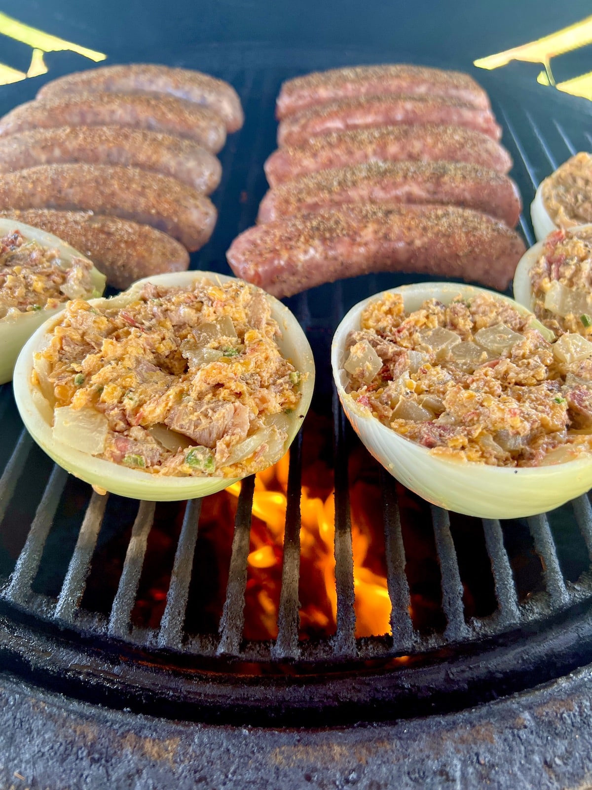 Brisket stuffed onions on the grill with sausages.