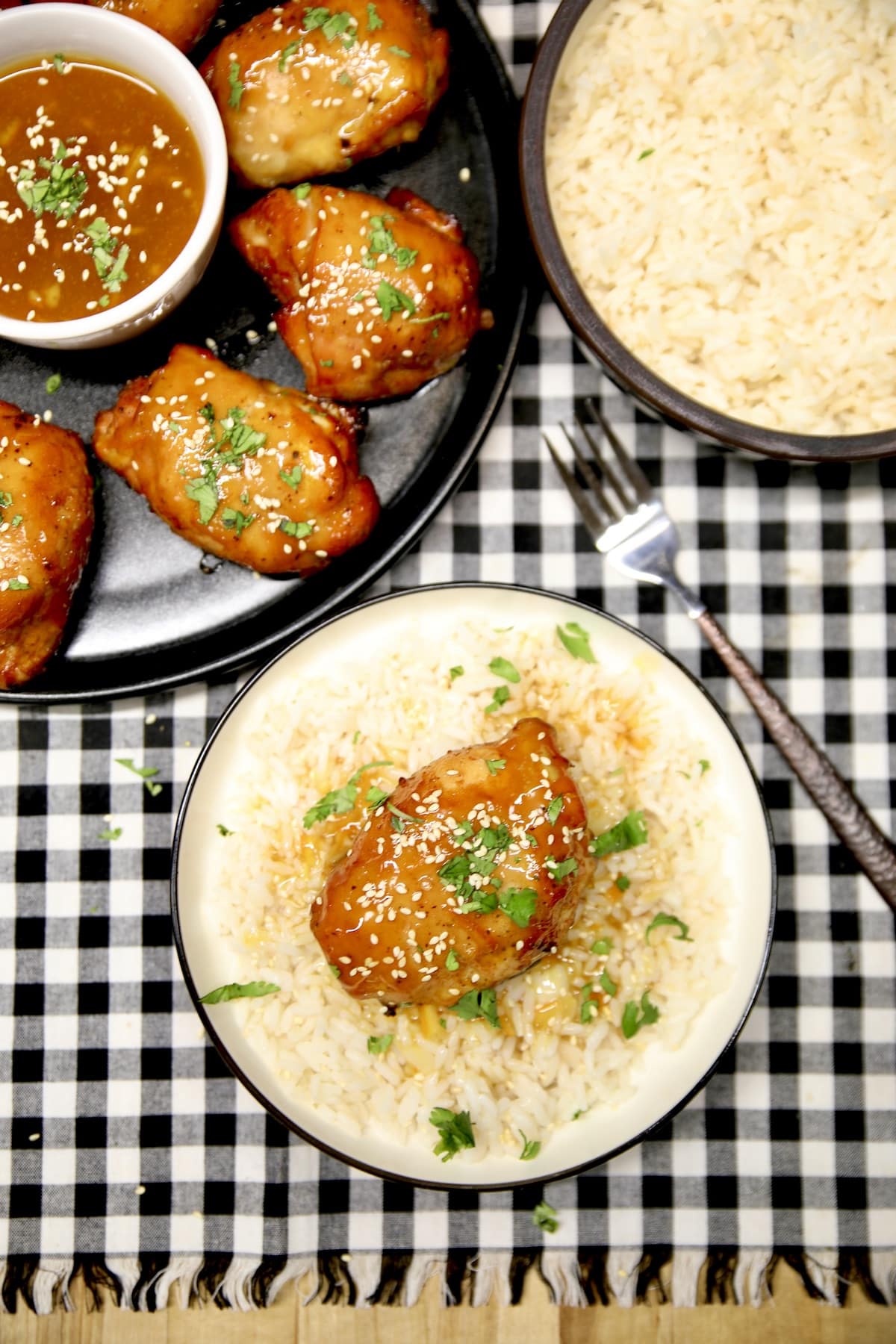 Platter of chicken, plated with rice and orange sauce.