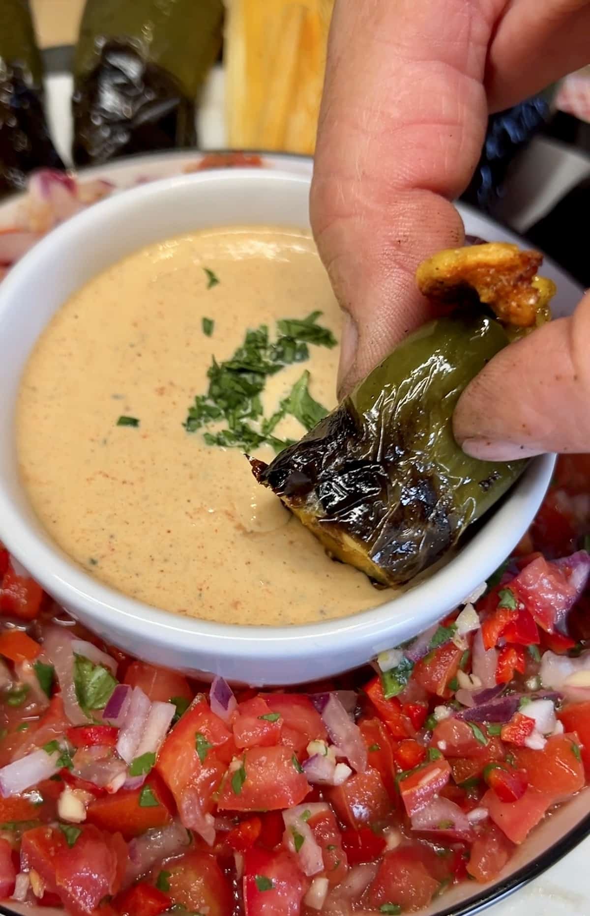 Jalapeno Tamale Poppers dipping into sauce.