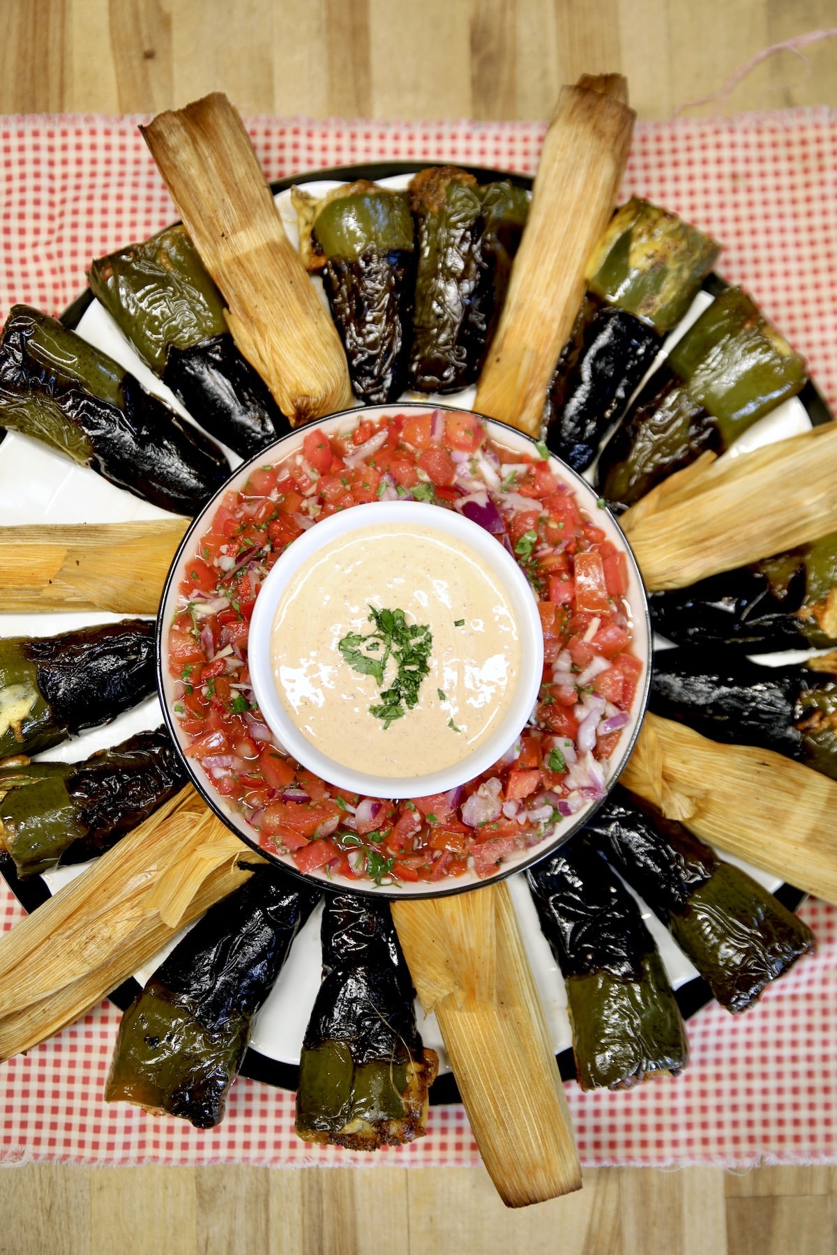 Jalapeno poppers with tamales platter with salsa and dip.