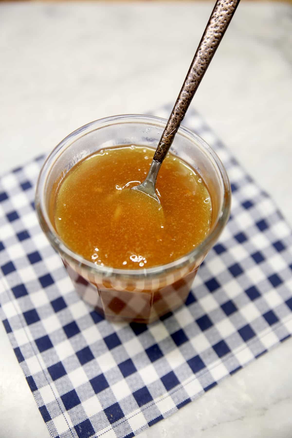 Jar of orange sauce with a spoon.