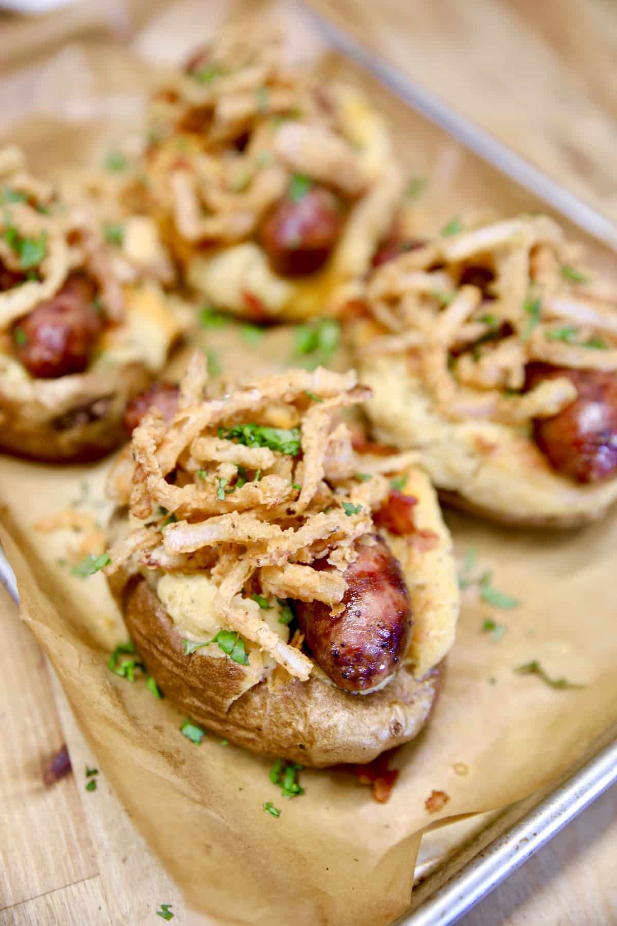 Sausage stuffed loaded baked potatoes with crispy onions.