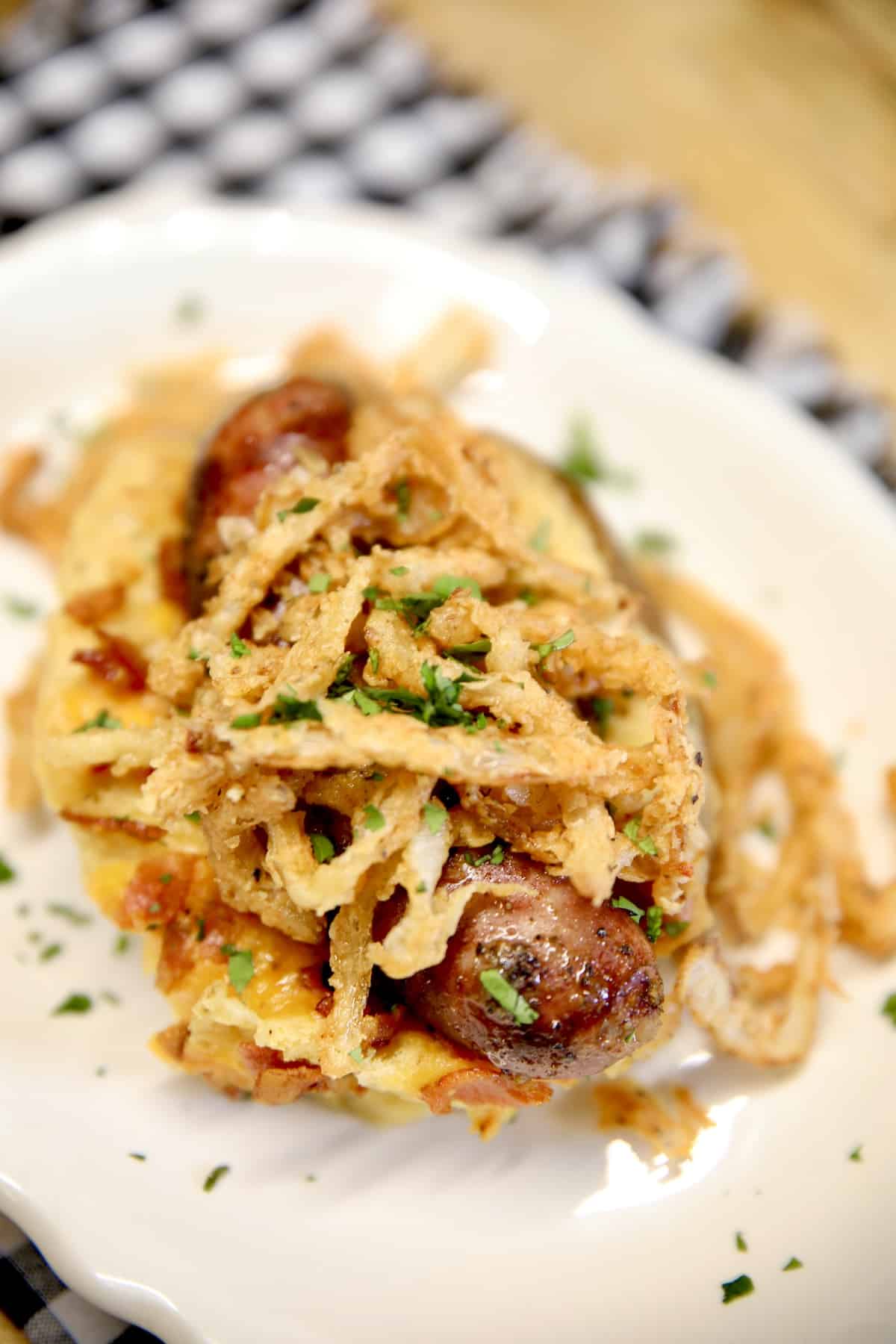 Plate with loaded potato, sausage and onions.