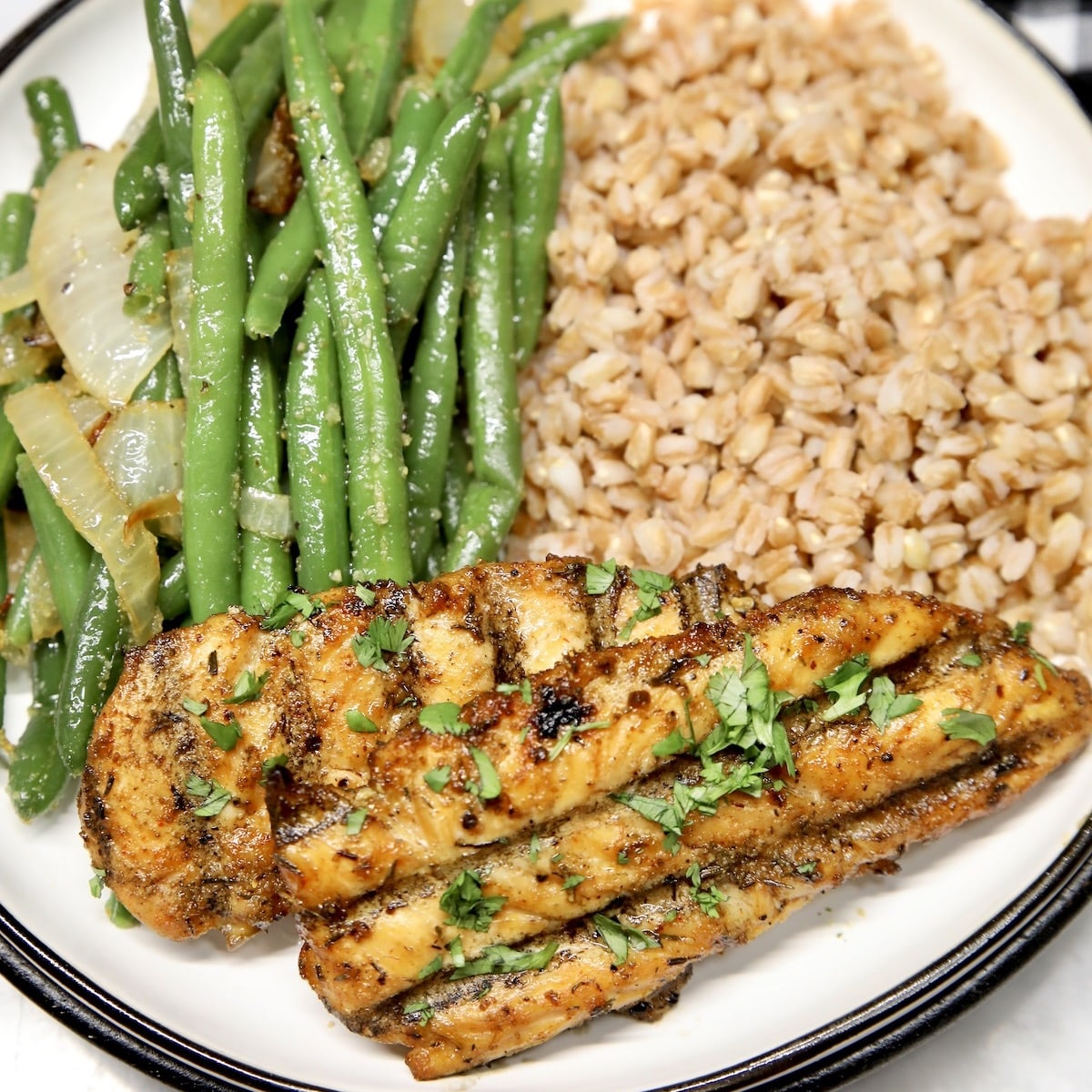 Plate of green beans, farro and chicken tenders.