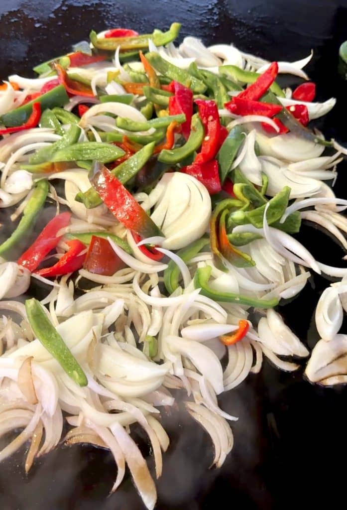 Cooking peppers and onions on blackstone griddle.