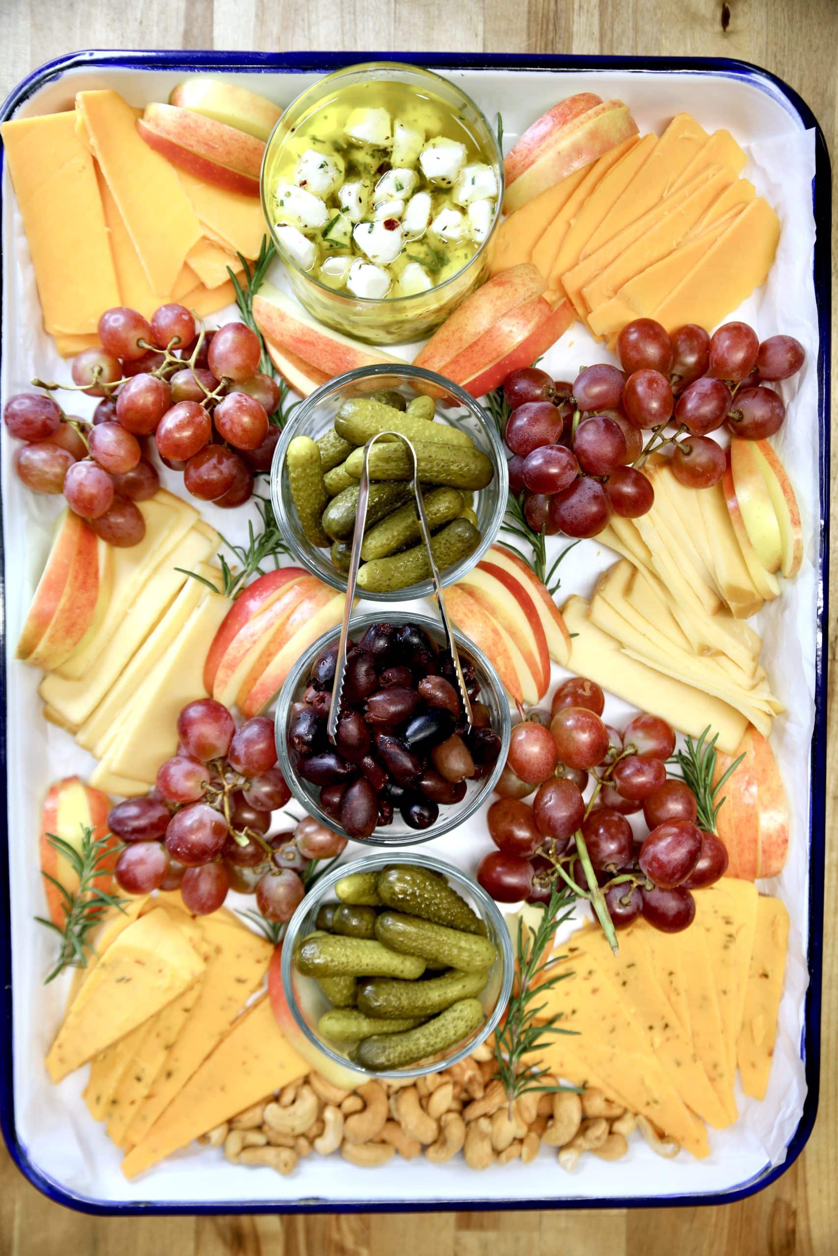 Cheese charcuterie with fruits, pickles, crackers.