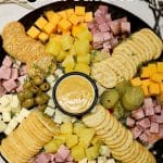Charcuterie board with ham, cheese, pineapple - text overlay.