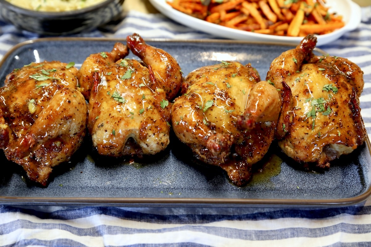 Grilled Cornish hens with orange glaze. Orange glazed Cornish hens on a platter.