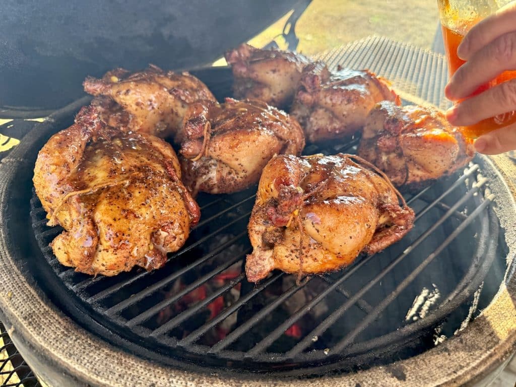 Glazing Cornish hens on a grill.