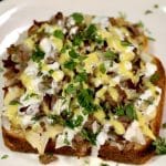 Open faced sandwich with roast beef, onion, melted cheese, ranch, honey mustard, cilantro.
