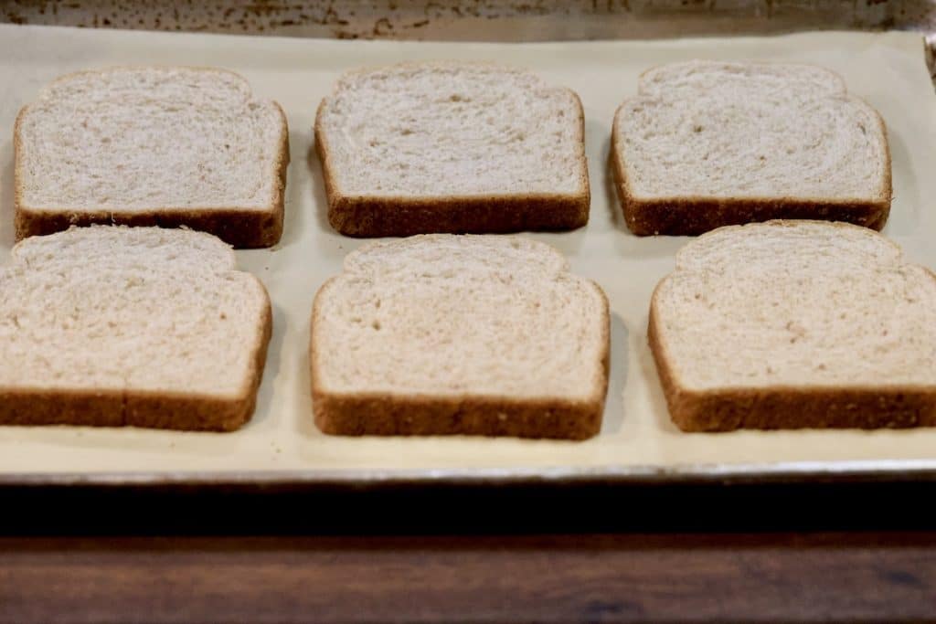 6 slices of bread on a parchment lined baking sheet.