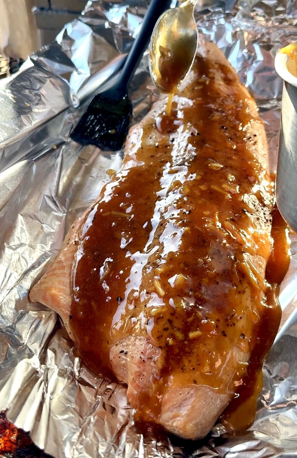 Orange glazed salmon on aluminum foil.