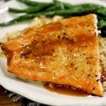 Salmon with orange glaze on a plate with rice and green beans.