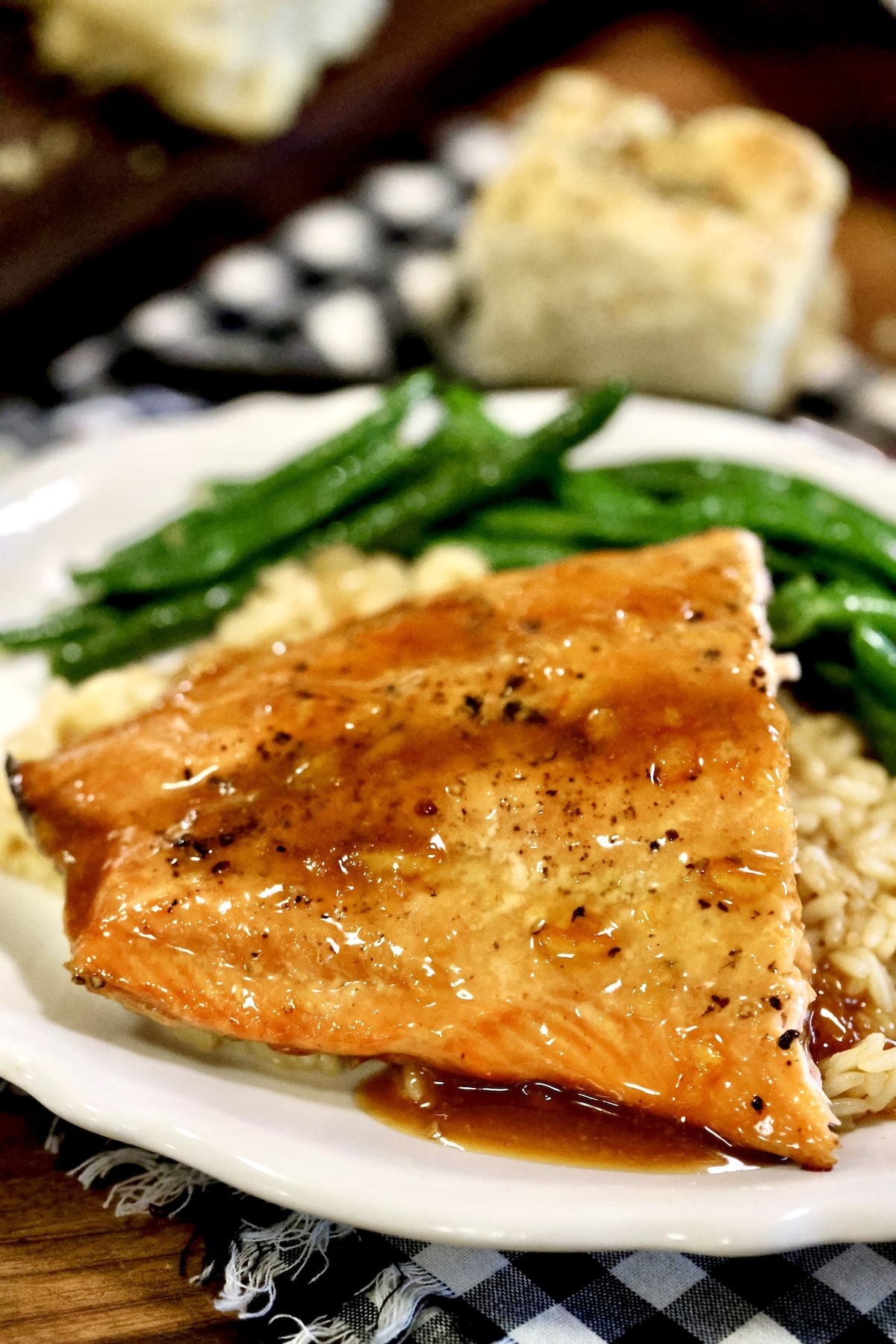 Grilled orange salmon on a plate with rice and green beans.