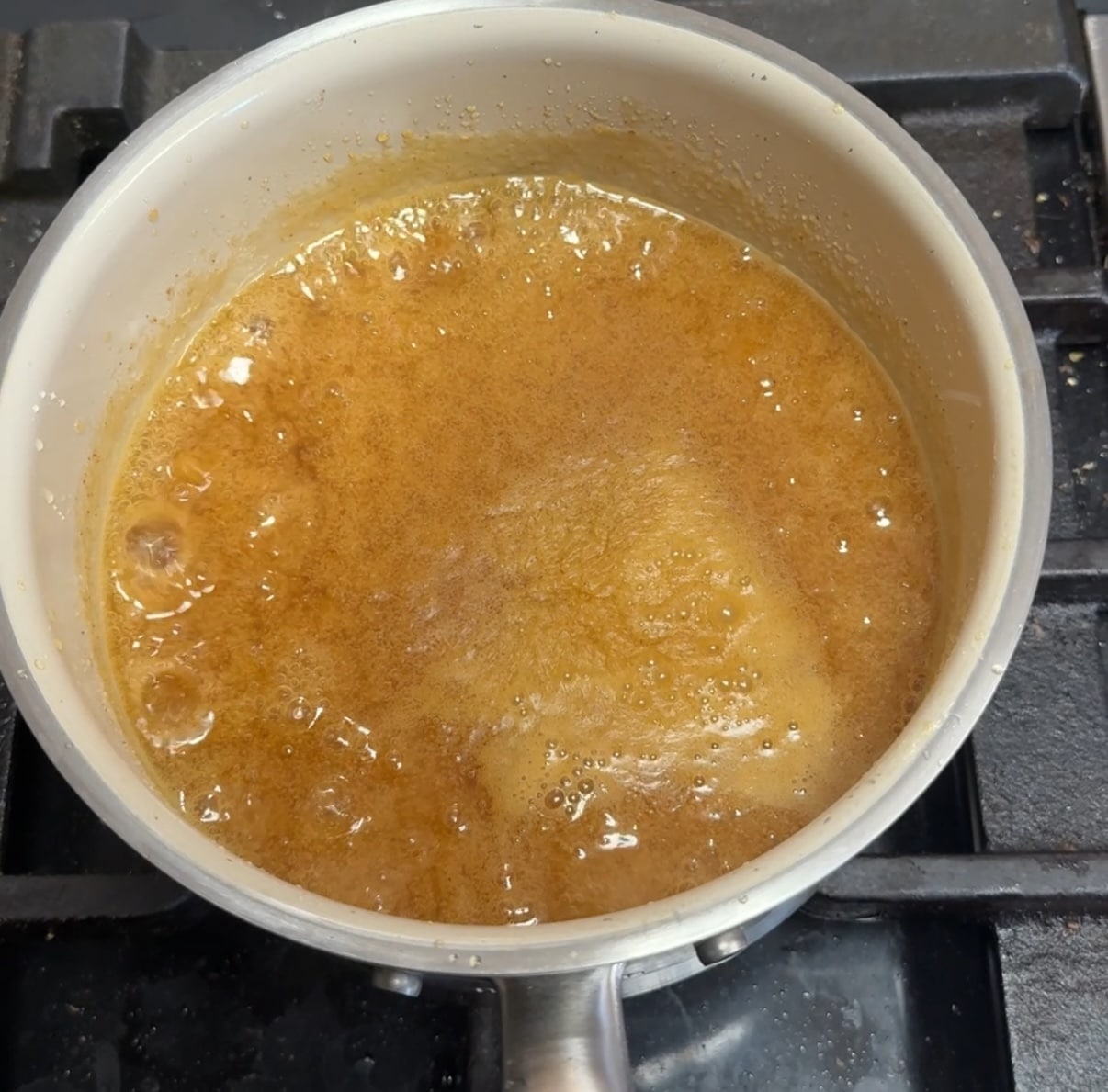 Pan of bubbling orange sauce.