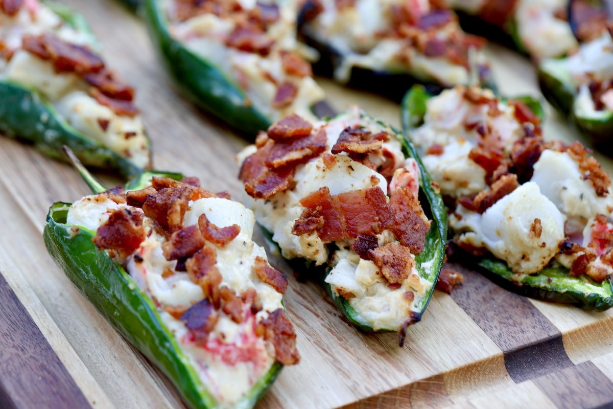 Crab rangoon stuffed peppers on a wood board.