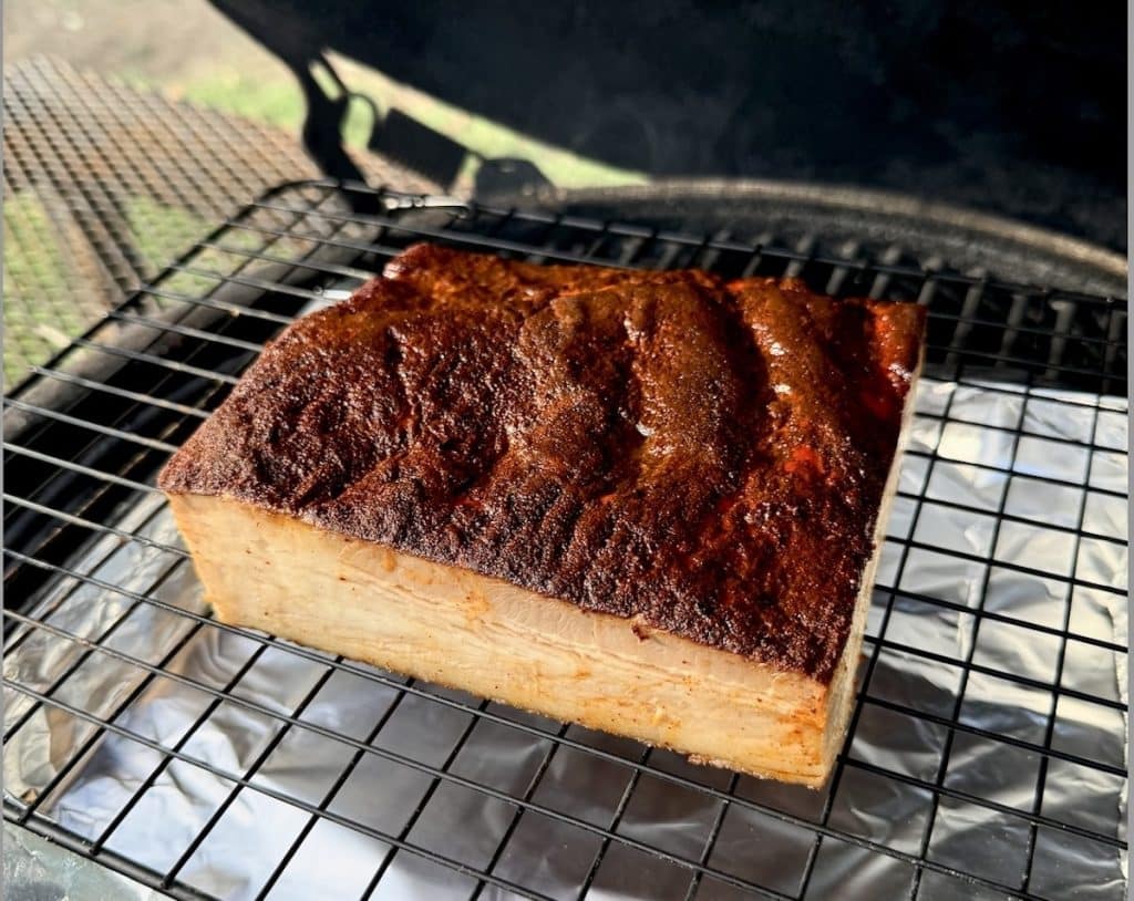 Grilled pork belly on a grill.